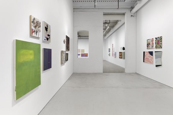 Installation view with paintings on the walls and looking from one gallery into another