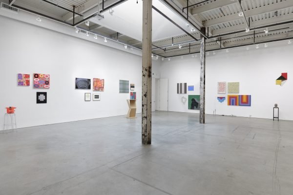Installation view showing paintings on the wall and three sculptures.